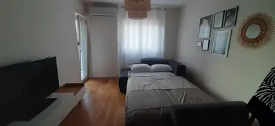 a bedroom with a bed and a flat screen tv at Lux Apartment PortoVista in Bar