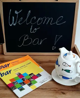 a chalk board with a welcome to bar and a tea pot and a book at Lux Apartment PortoVista in Bar