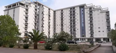 a large white apartment building with a parking lot at Lux Apartment PortoVista in Bar