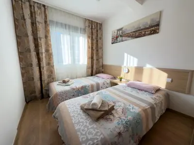 a hotel room with two beds with towels on them at Cosy two-bedroom apartment in Becici by sea and mountains in Becici
