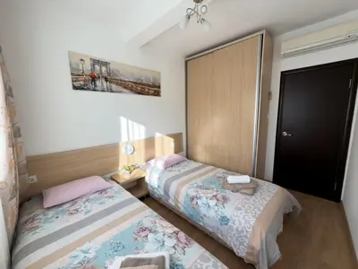 a bedroom with two beds and a closet at Cosy two-bedroom apartment in Becici by sea and mountains in Becici