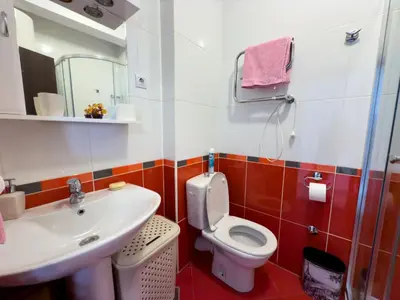 a bathroom with a toilet and a sink at Cosy two-bedroom apartment in Becici by sea and mountains in Becici