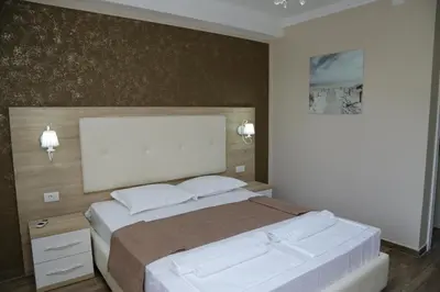 a bedroom with a large bed with white sheets at METROPOLIS in Ulcinj