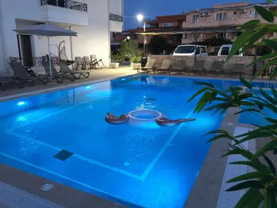 a swimming pool with blue water at night at METROPOLIS in Ulcinj