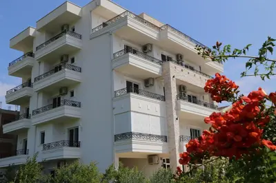 a white building with balconies and red flowers at METROPOLIS in Ulcinj