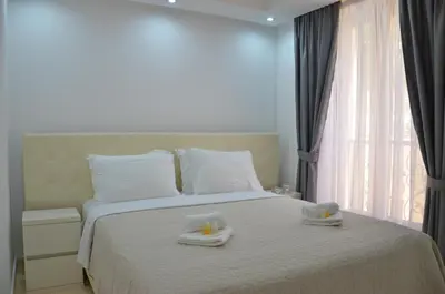 a bedroom with a bed with two towels on it at Andaluni Beach Apartments in Pržno