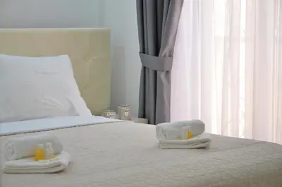 a bedroom with a bed with two towels on it at Andaluni Beach Apartments in Pržno