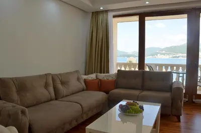 a living room with a couch and a table at Andaluni Beach Apartments in Pržno