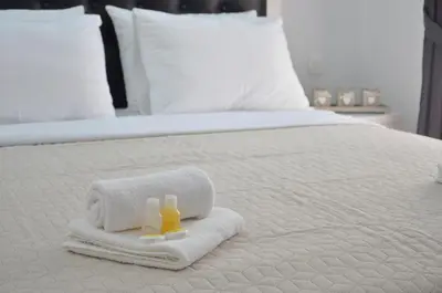 a bed with two towels and two bottles of shampoo at Andaluni Beach Apartments in Pržno