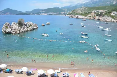a group of people swimming in the water at a beach at Andaluni Beach Apartments in Pržno
