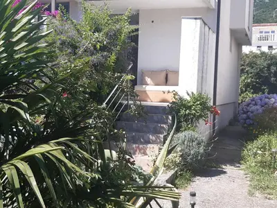 a couch sitting on the side of a house at Family apartment Garden and Sea in Petrovac na Moru
