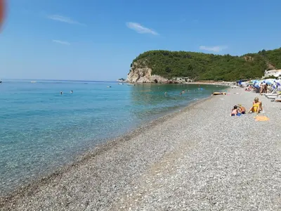 a group of people laying on a rocky beach at Family apartment Garden and Sea in Petrovac na Moru