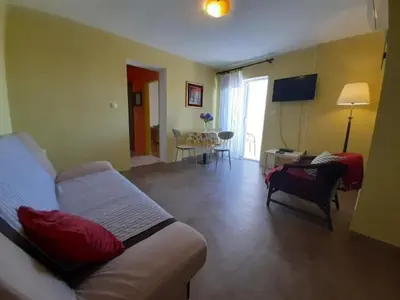 a living room with a couch and a living room with a table at Family apartment Garden and Sea in Petrovac na Moru