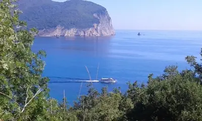 a boat in the middle of a large body of water at Family apartment Garden and Sea in Petrovac na Moru