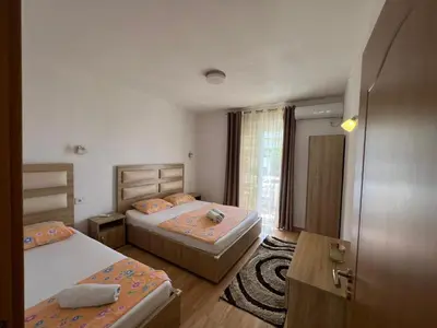 a bedroom with two beds and a door to a room at Kontiki Apartments in Ulcinj