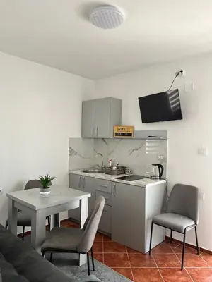 a kitchen with a table and a table and chairs at Kontiki Apartments in Ulcinj