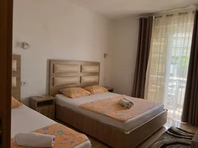 a bedroom with two beds and a teddy bear on the bed at Kontiki Apartments in Ulcinj