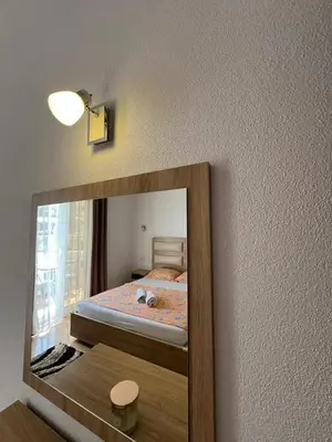 a mirror reflection of a bed in a bedroom at Kontiki Apartments in Ulcinj