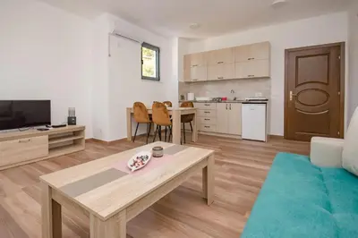 a living room with a coffee table and a kitchen at L’odore Del Mare in Sutomore