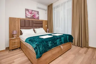 a bedroom with a large bed with a green blanket at L’odore Del Mare in Sutomore