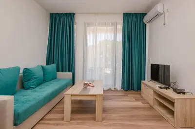 a living room with a blue couch and a television at L’odore Del Mare in Sutomore
