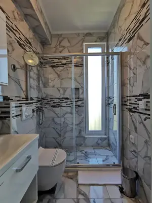 a bathroom with a shower and a toilet and a sink at Hotel MonteNino in Bar