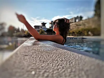 a woman laying on the edge of a swimming pool at Hotel MonteNino in Bar