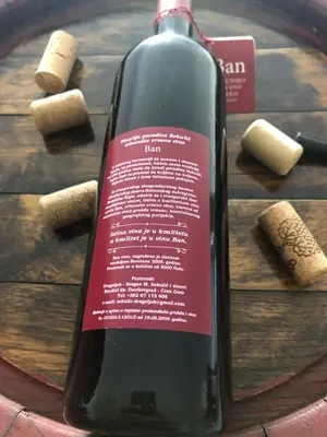 a bottle of wine sitting on top of a wooden table at Green Silence - Iva in Danilovgrad