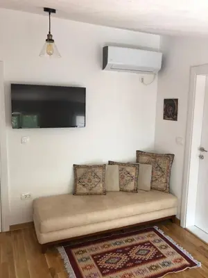 a couch in a living room with a flat screen tv at Green Silence - Iva in Danilovgrad