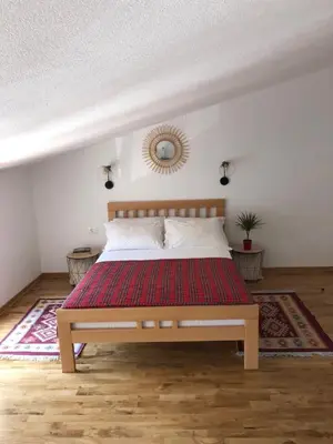 a bedroom with a bed with a red rug at Green Silence - Iva in Danilovgrad