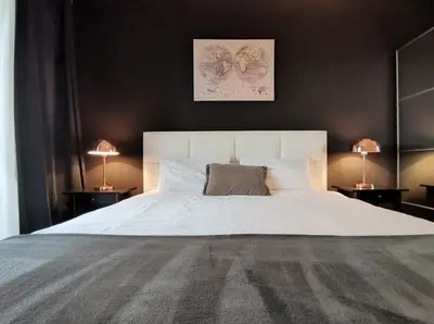 a bedroom with a large white bed with two lamps at Wonderful Apartment near City Mall in Podgorica