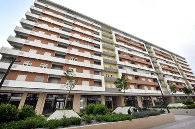 a large apartment building with trees in front of it at Wonderful Apartment near City Mall in Podgorica