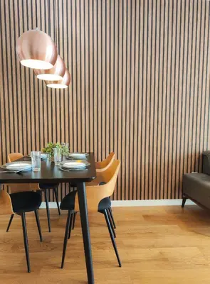 a dining room with a black table and chairs and a wall at Wonderful Apartment near City Mall in Podgorica