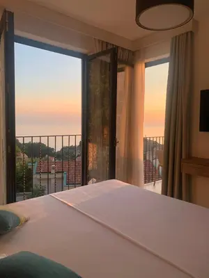 a bedroom with a bed and a large window at REZEVICI BOUTIQUE VILLA in Petrovac na Moru