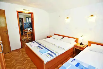 a bedroom with two beds and a mirror at MARINOVIC APARTMENTS in Budva