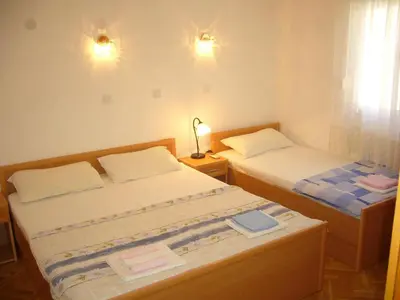 a bedroom with two beds and a lamp and a window at MARINOVIC APARTMENTS in Budva