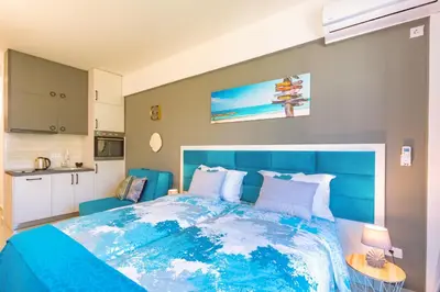 a bedroom with a blue bed and a kitchen at Sea&Center Lux in Bar
