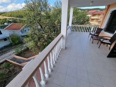 a balcony with chairs and tables on a house at Дом для семейного отдыха в Утехе, Черногория in Utjeha
