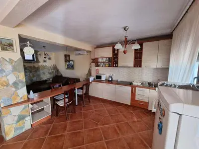 a kitchen with white cabinets and a table in it at Дом для семейного отдыха в Утехе, Черногория in Utjeha