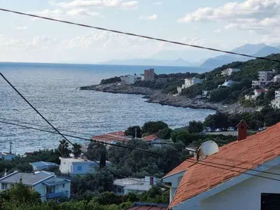 a view of the ocean from a town with houses at Дом для семейного отдыха в Утехе, Черногория in Utjeha