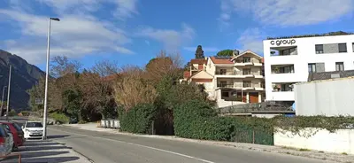 a building on the side of a road next to a building at Java Apartments in Dobrota
