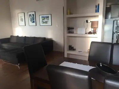 a living room with a black couch and a table at Apartments Vila Andja in Sveti Stefan