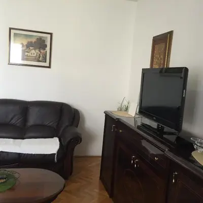 a living room with a couch and a flat screen tv at Apartments Vila Andja in Sveti Stefan