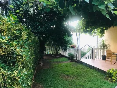 a garden with a fence and a wooden deck at Apartments Vila Andja in Sveti Stefan