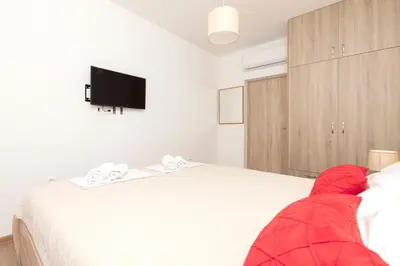 a bedroom with a bed and a tv on the wall at Seafoam apartment in Kotor