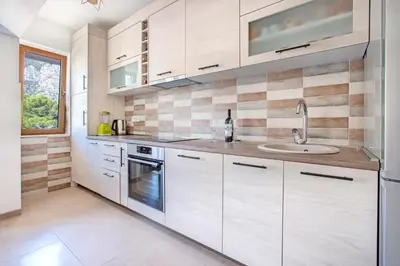 a kitchen with white cabinets and a sink at Seafoam apartment in Kotor