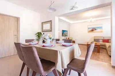 a dining room and living room with a table and chairs at Seafoam apartment in Kotor
