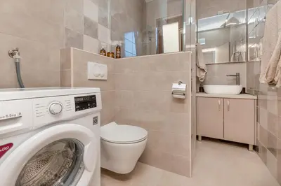 a bathroom with a washing machine and a toilet at Seafoam apartment in Kotor