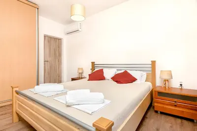 a bedroom with a large bed with red pillows at Seafoam apartment in Kotor