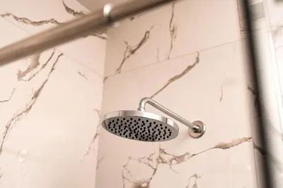 a shower with a shower head in a bathroom at David Lux beach rooms in Dobra Voda